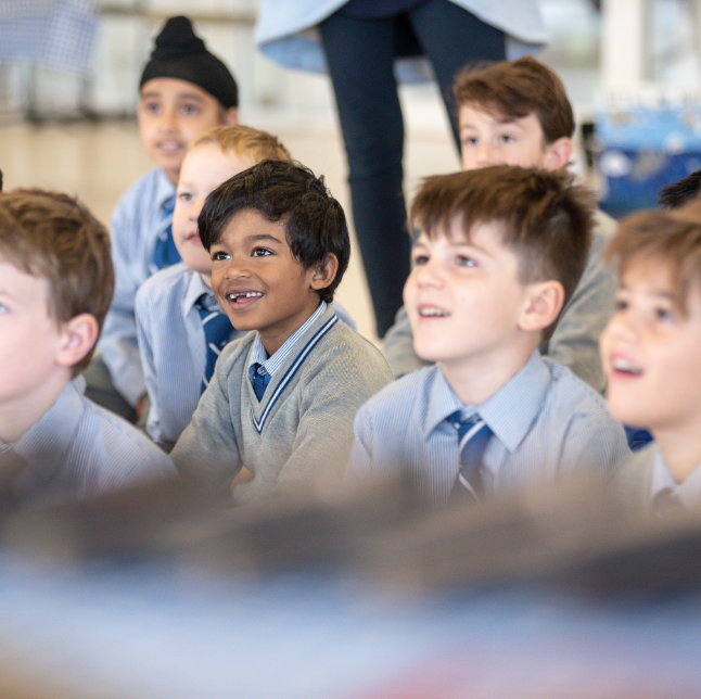Young school boys sitting in a classroom smiling