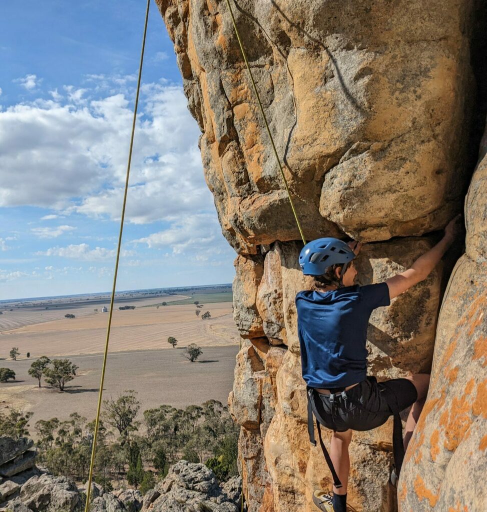 Student climbing a rock 