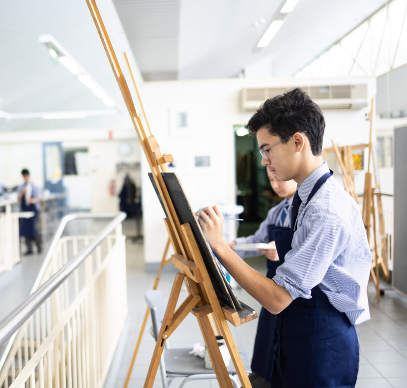 Student in a classroom painting