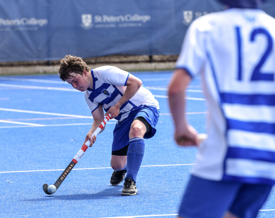 Student playing hockey about to pass the ball