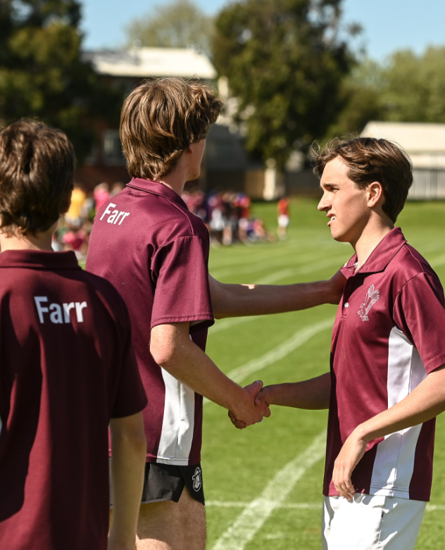 Two students handshaking after a running race